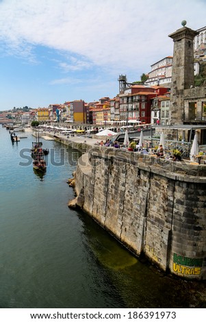 PORTO, PORTUGAL - SEPTEMBER 5, 2013: Unidentified people by the Douro river in Porto, Portugal. Historic Centre of Porto is a UNESCO World Heritage Site since 1996.