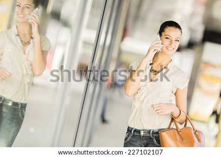 Pretty young woman with mobile phone on the street