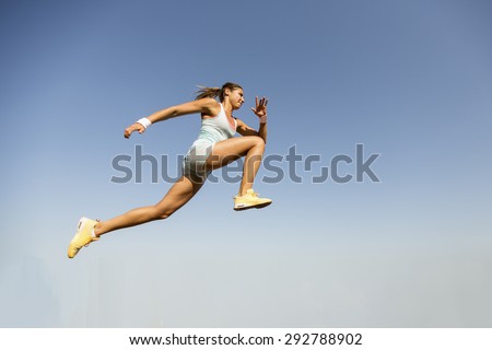 Young woman taking long jump