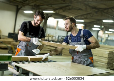 Young workers work in a factory for the production of furniture