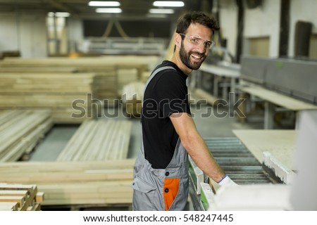 Handsome young man working in the furniture factory