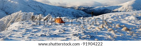 tent set up in snow with mountains