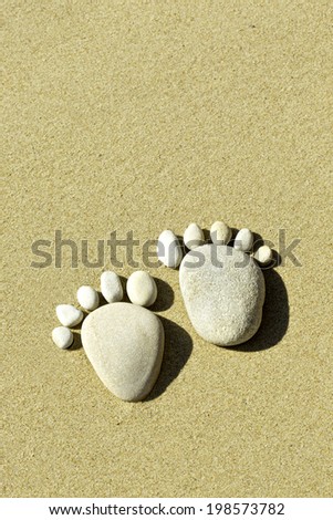 two feet made out of stones indicating footprints in the sand