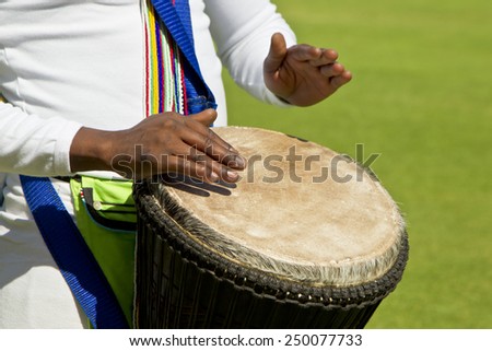 African drummers hands playing a skin covered traditional drum