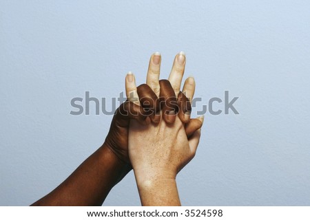 different ethnic cultures locking hands in the air