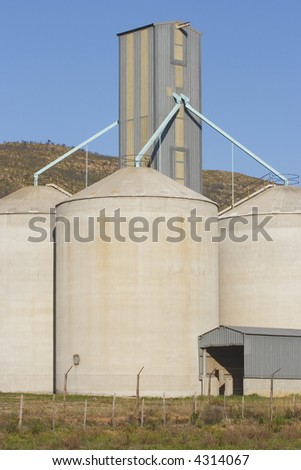 grain silos holding wheat next to a hill