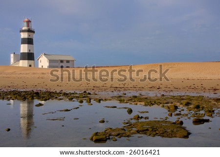 lighthouse reflection in the calm waters of a coastal pool