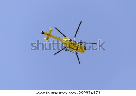 Clacton-on-sea, Essex, England, UK: 1 August 2013- Helicopter rescue, Yellow helicopter in the air while flying in a  blue sky, on its way to rescue someone.