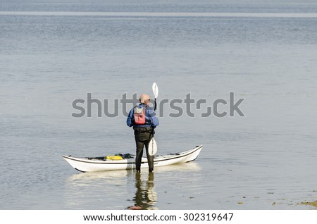 River Stour, Manningtree, Essex, England UK:  30 September 2014- A man waiting for his friends, so he can get started in his canoe,