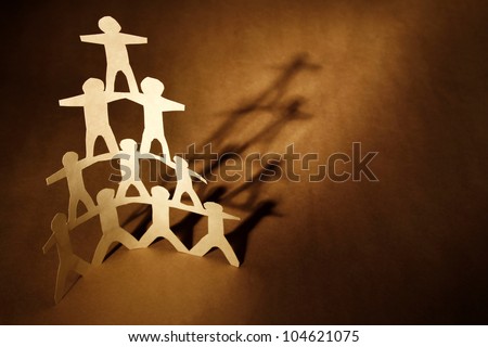 Human team pyramid on brown background
