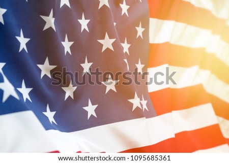 Closeup of rippled American flag. Sunlight shining from end of