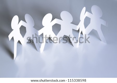 Team of six paper doll people holding hands. Teamwork concept