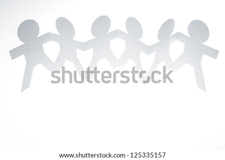 Group of paper chain people holding hands together.
