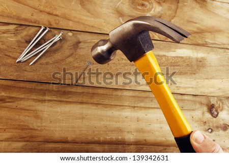 A builder hammers a nail into wood