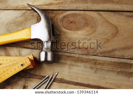 Nails, hammer and folding ruler on wood