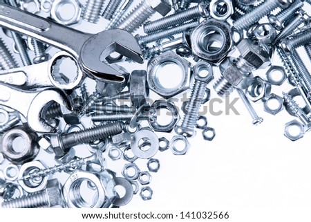 Wrenches, nuts and bolts on plain background