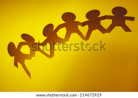 Team of paper doll people holding hands