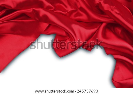 Closeup of folds in red silk fabric on plain background. Advertising copy space