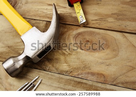 Hammer, nails and tape measure on wood