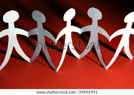 Paper doll people holding hands on red background