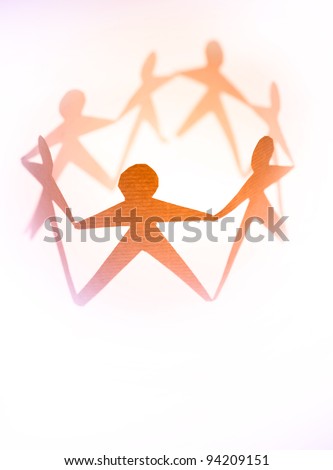 Paper doll people in a circle holding hands on plain background
