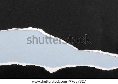 Hole ripped in paper on blue background. Copy space