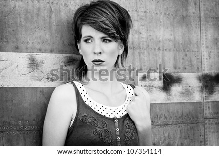 Young sad woman leans against wall and waiting someone.