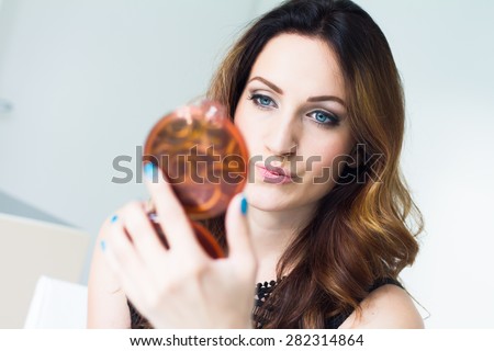 Young woman looking into mirror