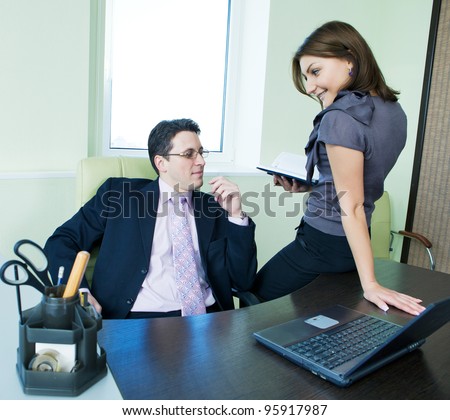 Business assistant flirting with  boss in office interior