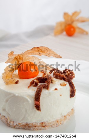 Cream cheese cake with crispy crust, vanilla, exotic fruit and chocolate decor. white background, white linen