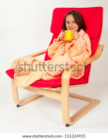 Little girl, caucasian, european, brown hair, blue eyes, dressed in a robe, sitting in an armchair with the flu, drinking tea