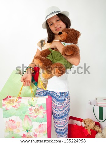Little girl, caucasian, european, brown hair, blue eyes, back from shopping, happy with her teddy bear