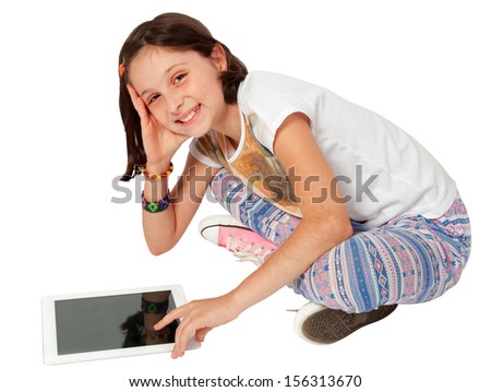 Little girl, caucasian, european, brown hair, blue eyes, sitting on the floor and playing with the tablst, isolated on white background