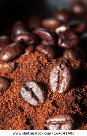 Closeup of coffee beans at roasted coffee heap. Coffee bean on macro ground coffee background. Arabic roasting coffee - ingredient of hot beverage.