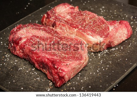 Raw seasoned rib eye steak