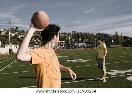 Men about to throw  a pass on a football field