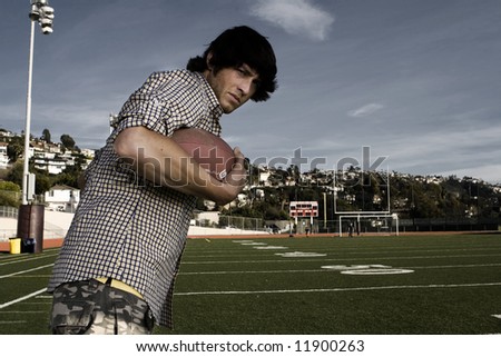 Young man running with football on a field