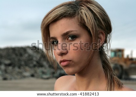 Sexy fashion model standing in a deserted industrial lot