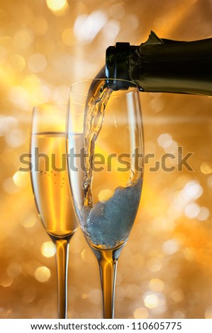 champagne in wineglass on a yellow background.