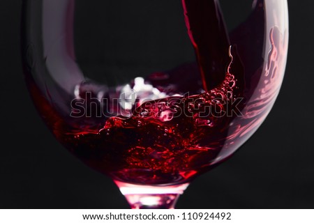Red wine on a black background, abstract splashing.