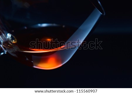 snifter with brandy on a dark background.