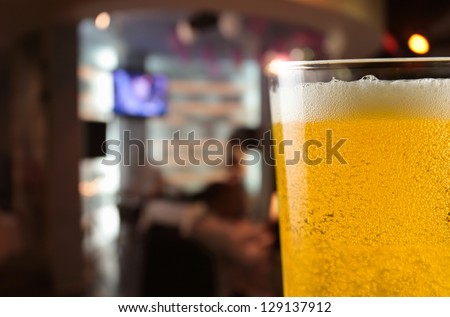 Beer mug with froth on a table in bar