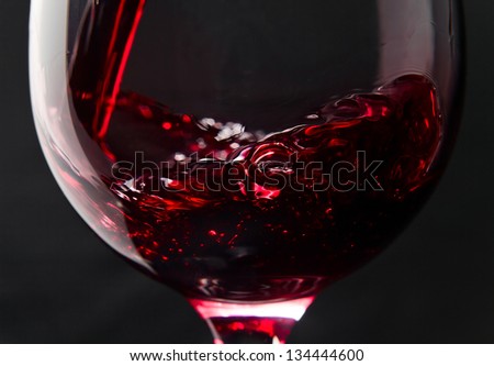 Red wine in wineglass on a black background