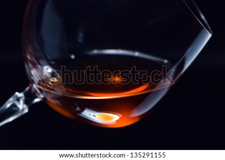 snifter with brandy on a dark background.