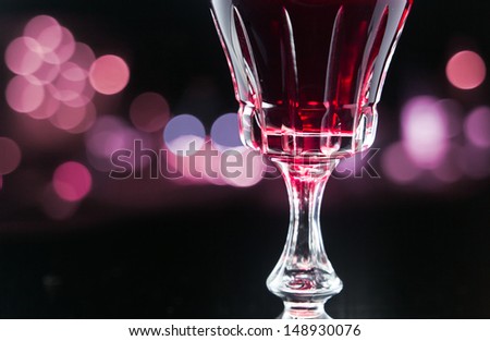 glass with red wine on a black background