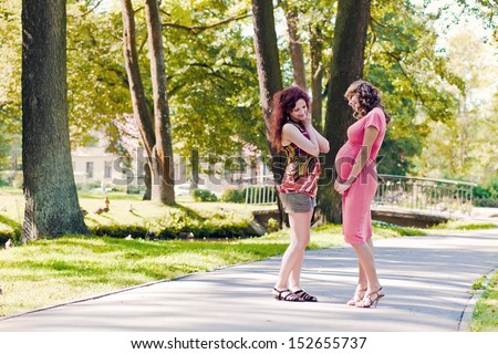 The pregnant woman talks to the girlfriend in park