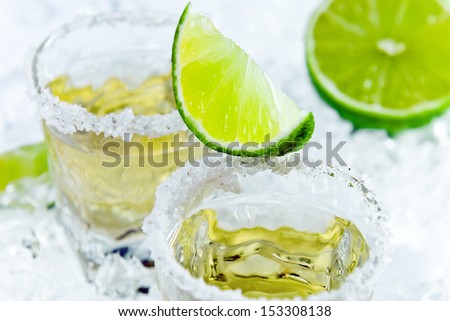 gold tequila with salt and lime on a ice.