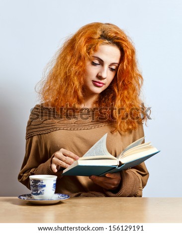 young  beautiful woman with book and tea cup
