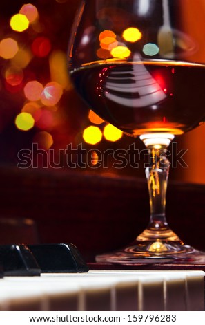 snifter with brandy on old piano in bar