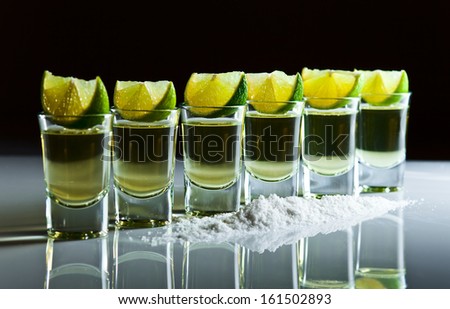 tequila , lime and salt on white reflexive table